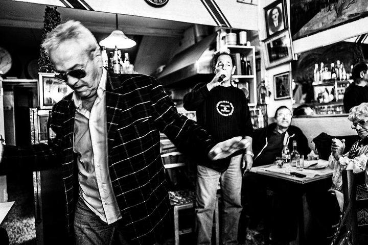Black and white photograph of a dancing man in motion while Theo sings behind him.