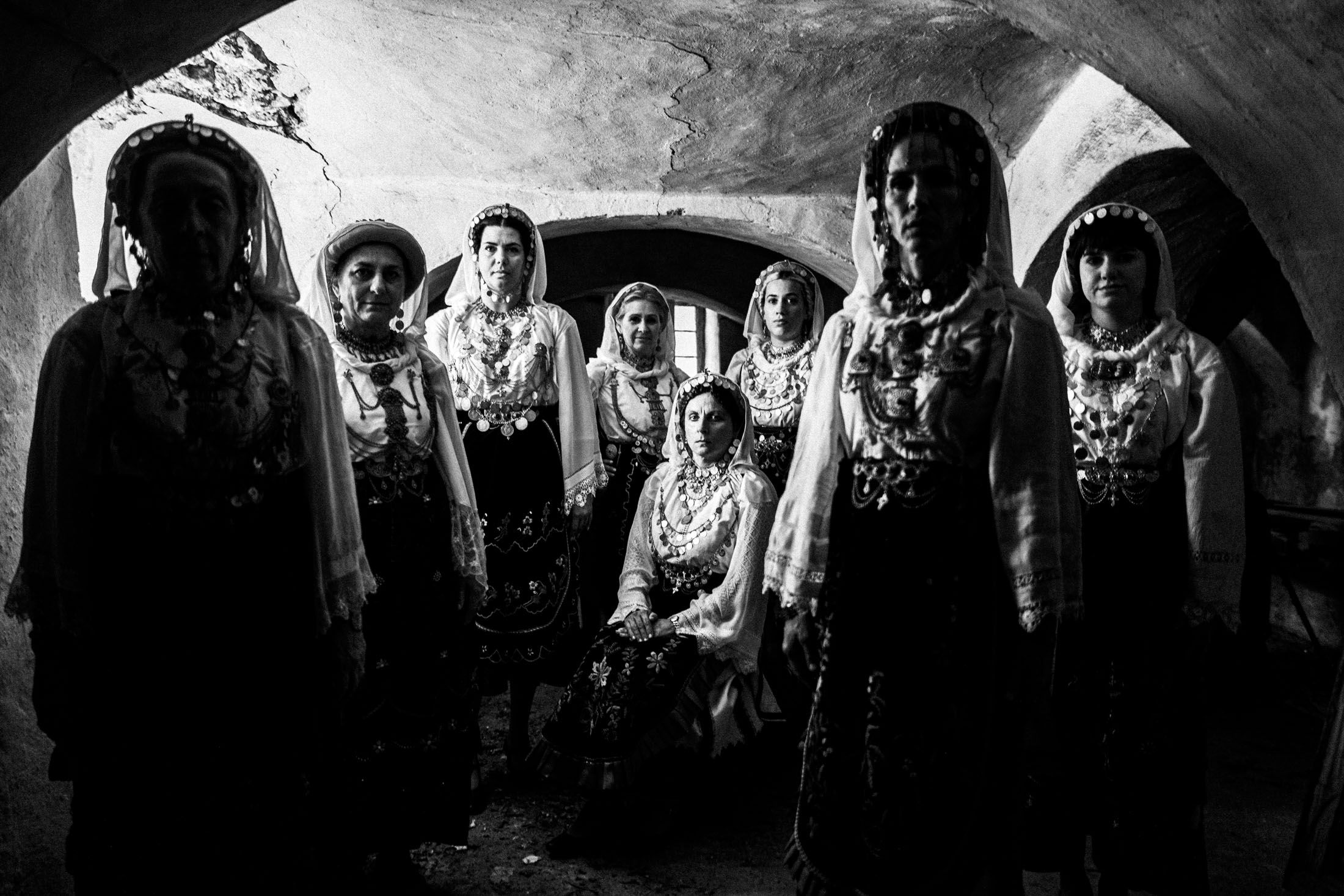 A group of women wearing the local costumes of Agia Anna, Euboea, inside an old local basement