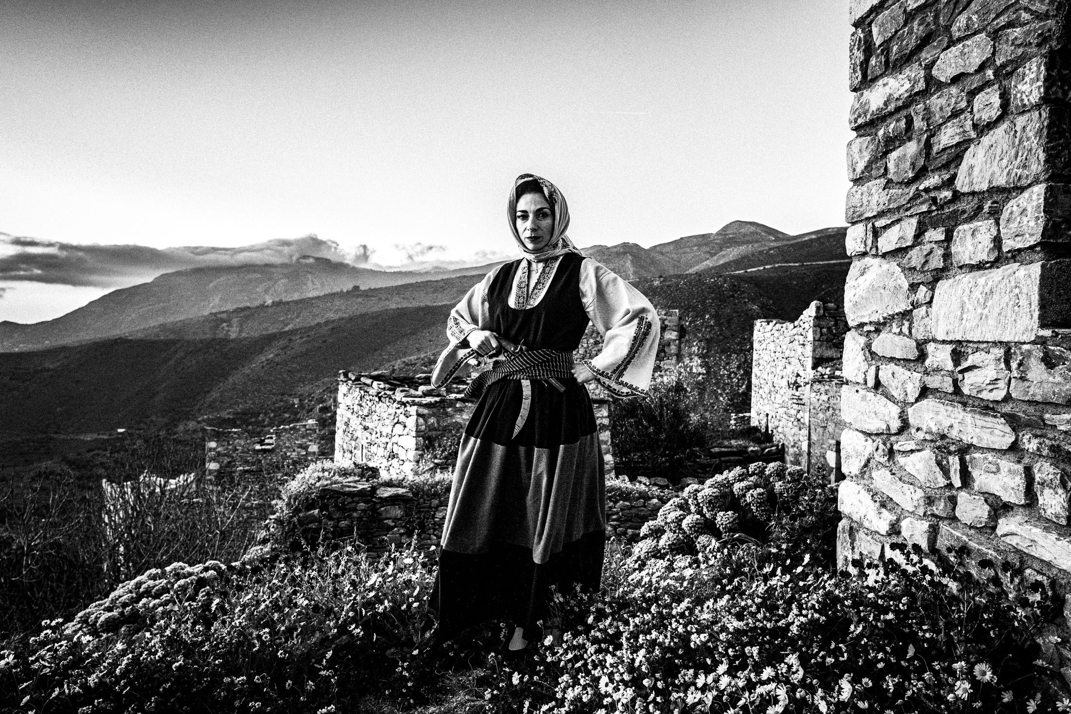 A woman wearing the local dress of Mani, Peloponnese, standing in the abandoned city of Vathia.
