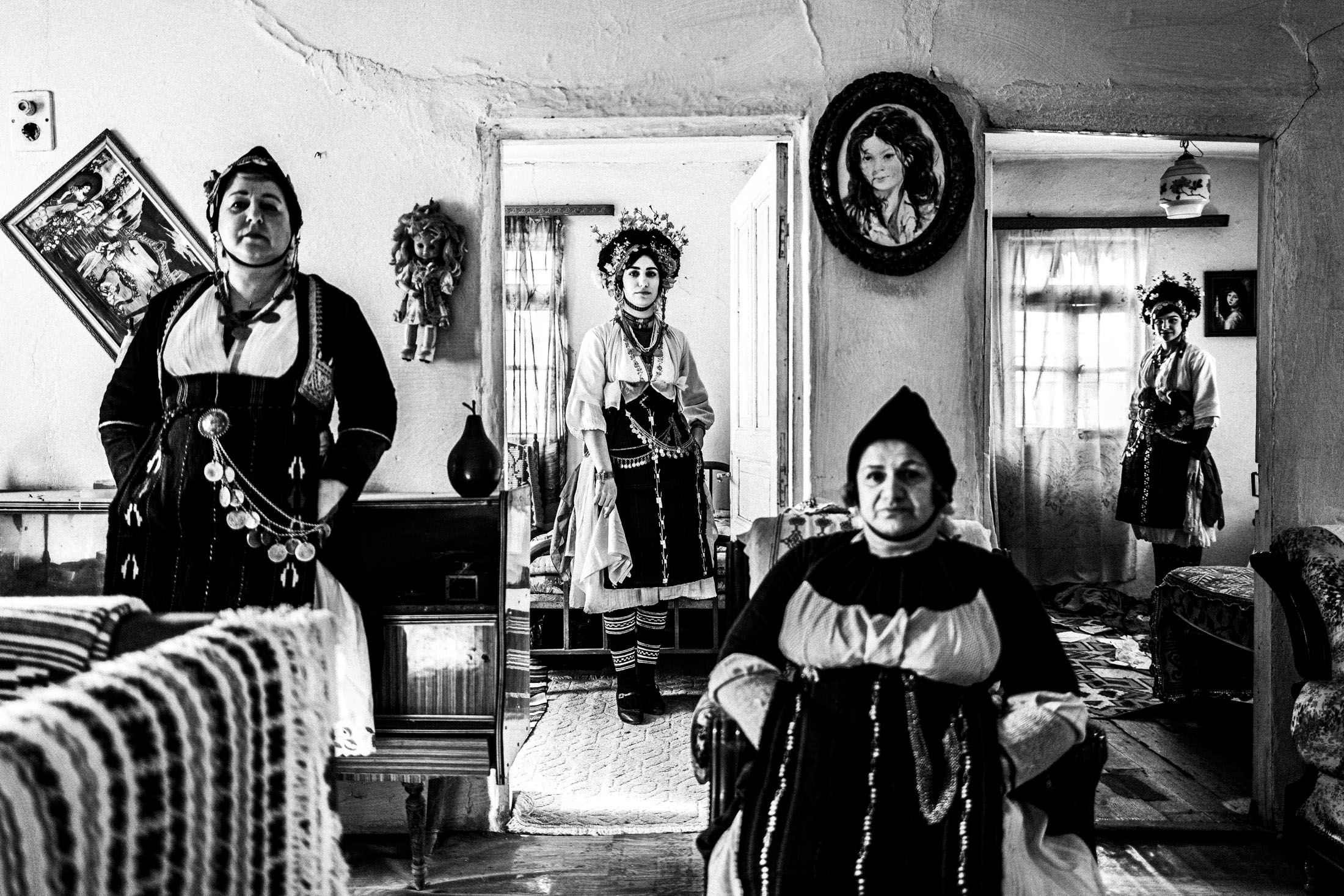 Four women wearing the traditional costumes of Roumlouki in Meliki, inside a local home.