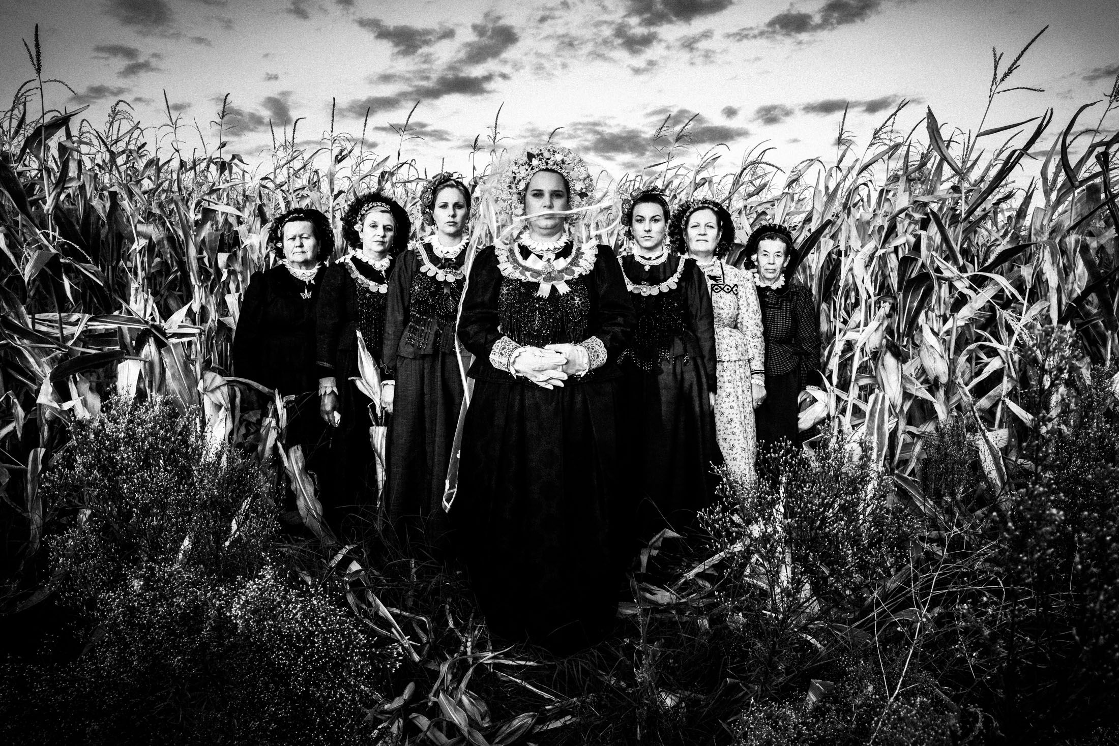 Women wearing the local costumes of Nea Vyssa in Evros amongst corn in a field