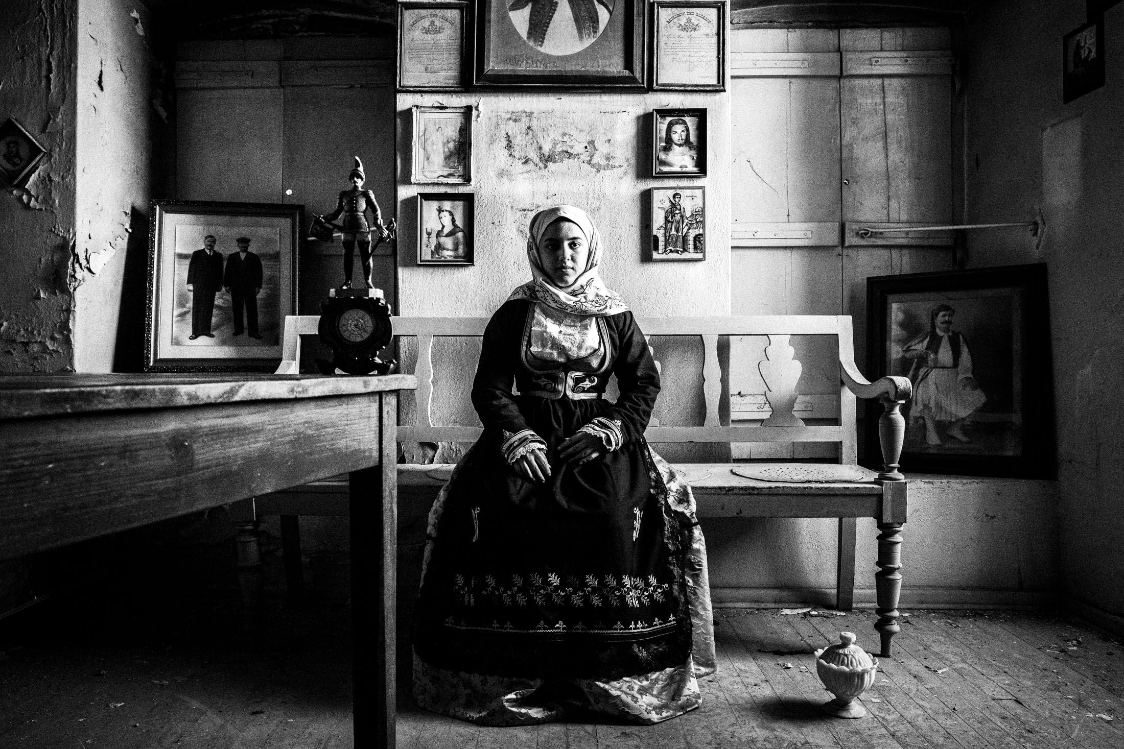 A woman wearing the traditional costume of Geraki, Laconia, sitting inside an old abandoned local house