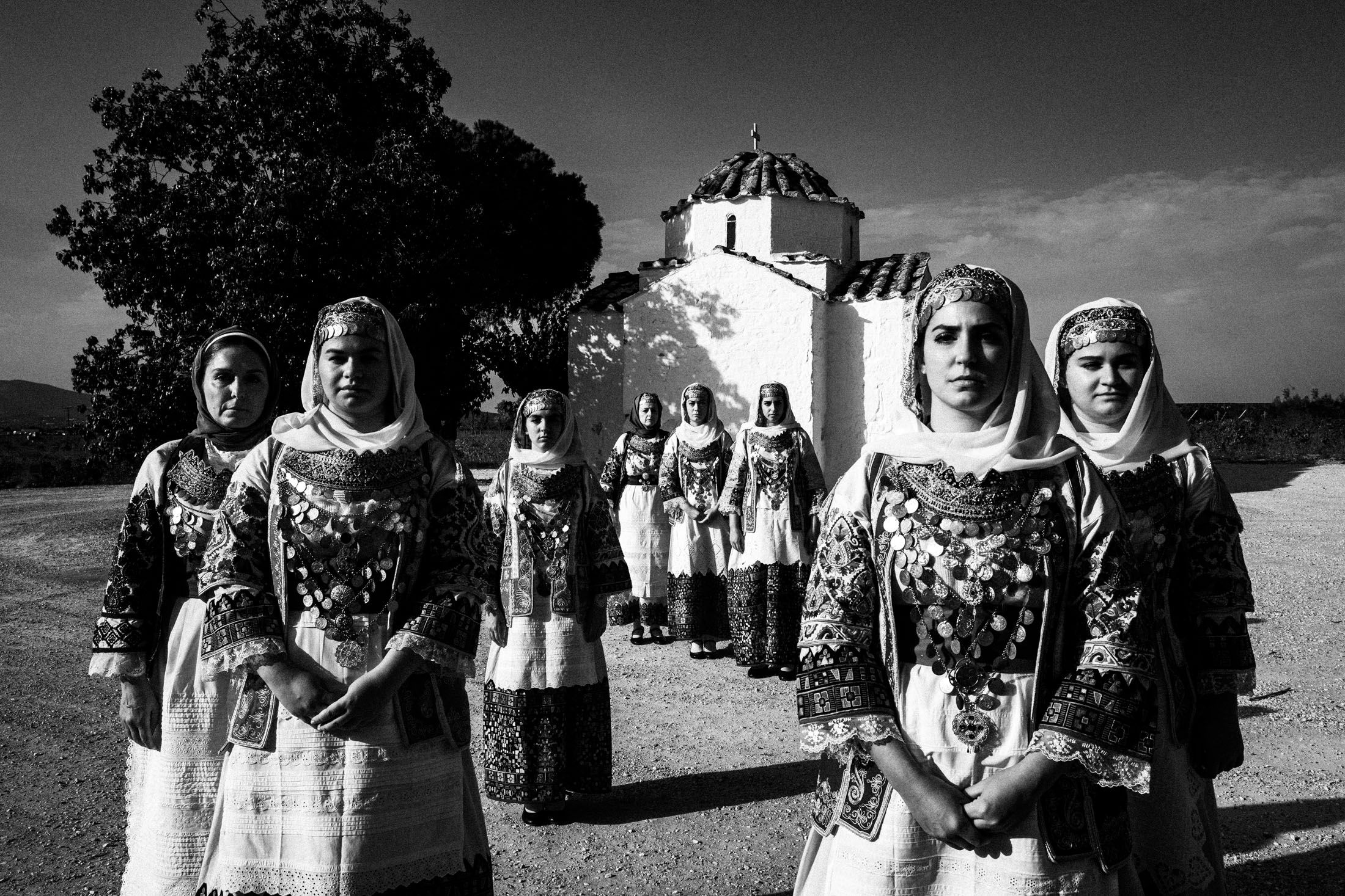 Women wearing the costumes of Markopoulo, Attica standing outside a local church