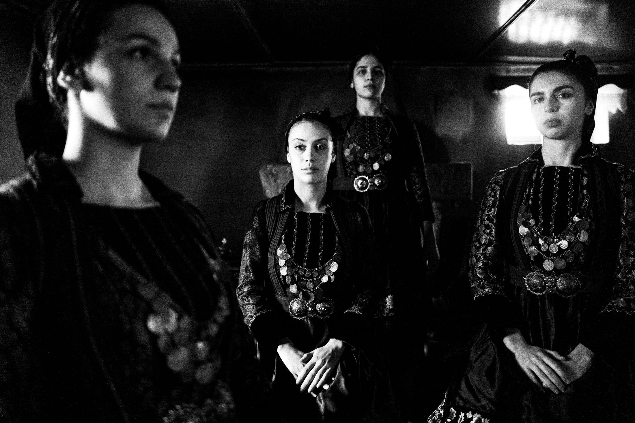 Women wearing the local costumes of Kerasovo, aka Agia Paraskevi, in Epirus inside a local house