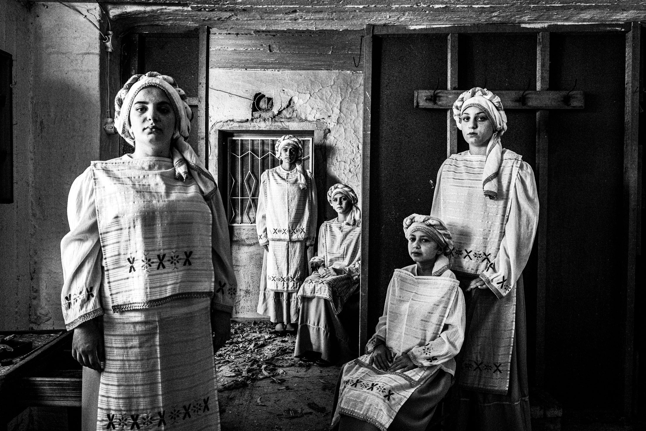 Five young women Wearing the local costumes of Dafnonas standing inside an old abandoned local house.