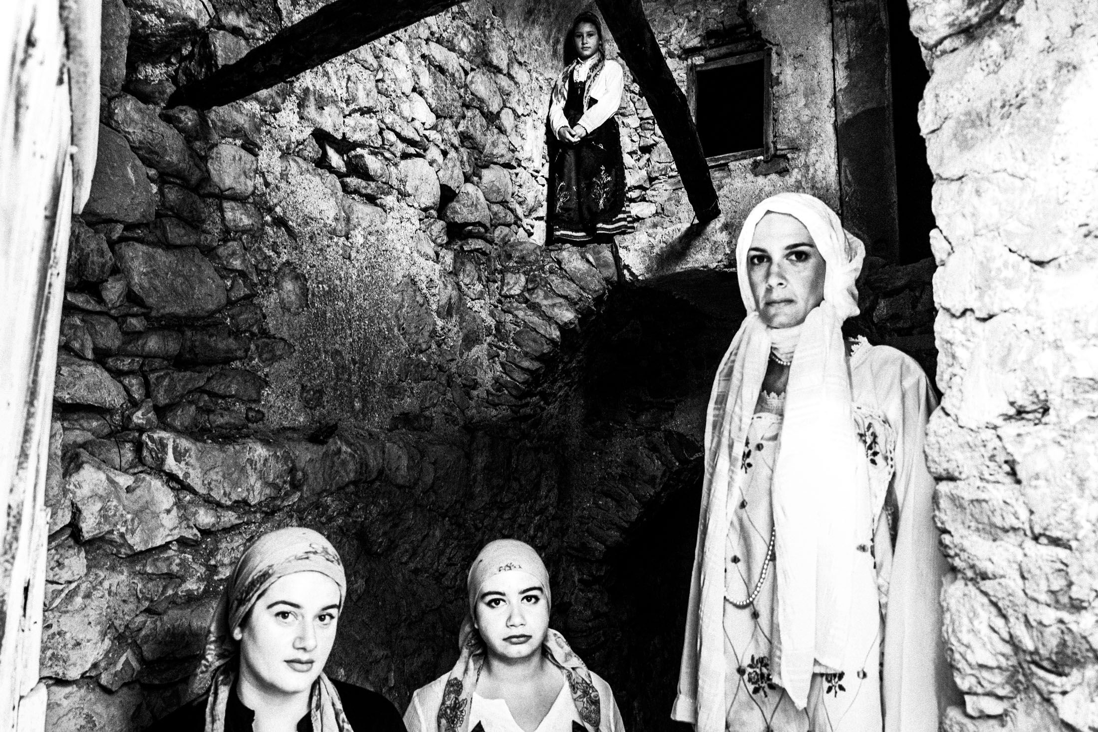 Women inside a local old stone building, wearing the costumes of Armolia, Chios