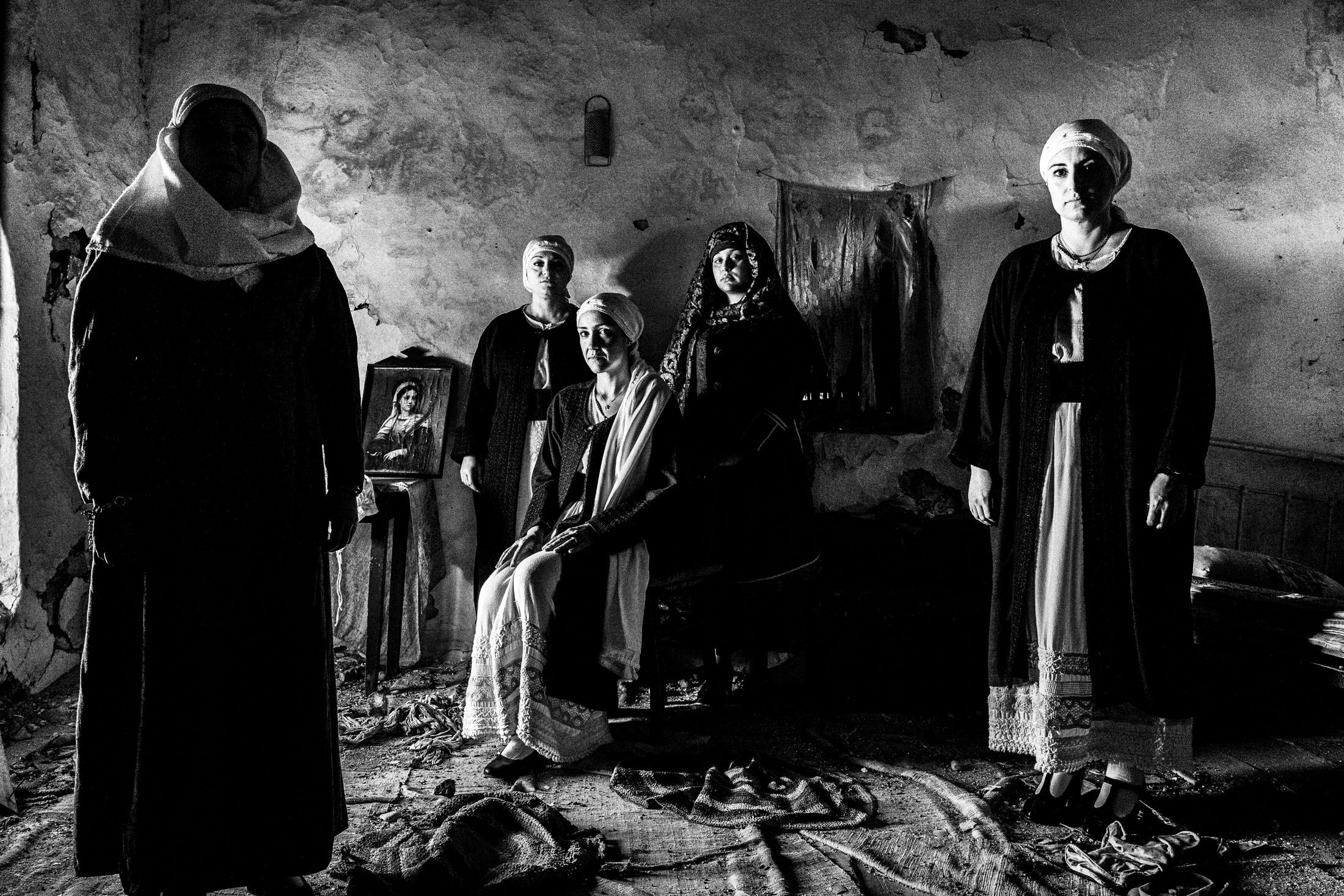 Five women inside an old abandoned local house, wearing the local costumes of Kardamyla, Chios