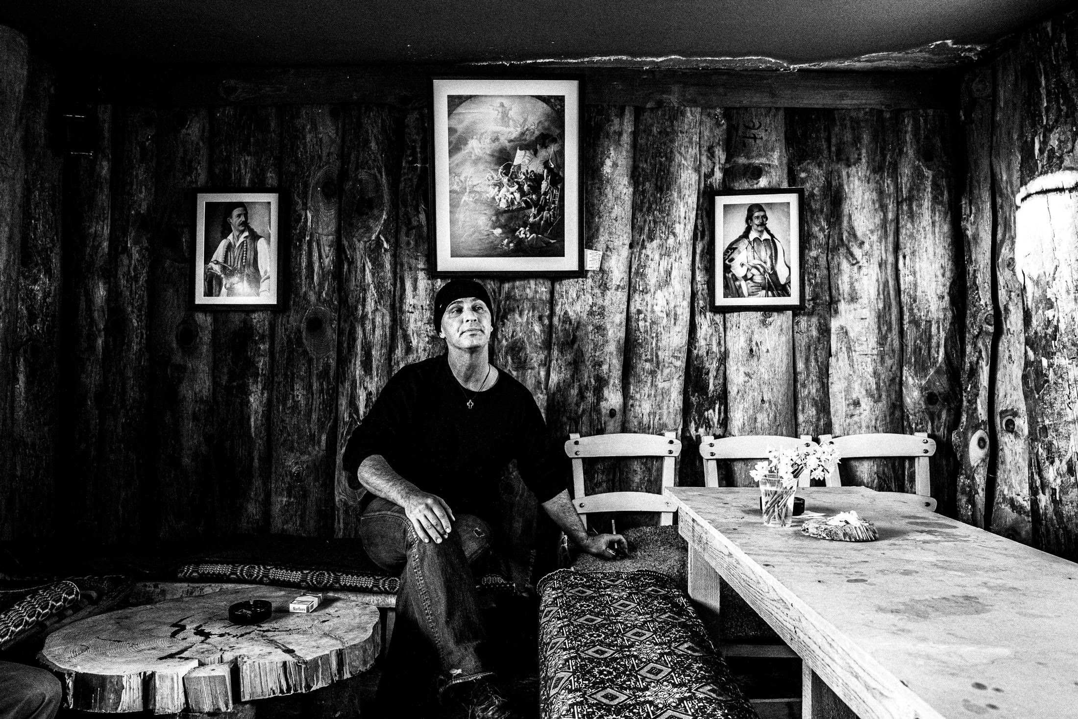 A man seated inside a wooden hut at the winter Ai-Symios festival in Messolonghi.